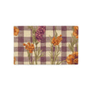 A rectangular pillow cover featuring a purple and beige gingham checkered pattern overlaid with orange flowers and green stems, shown flat against a white background.