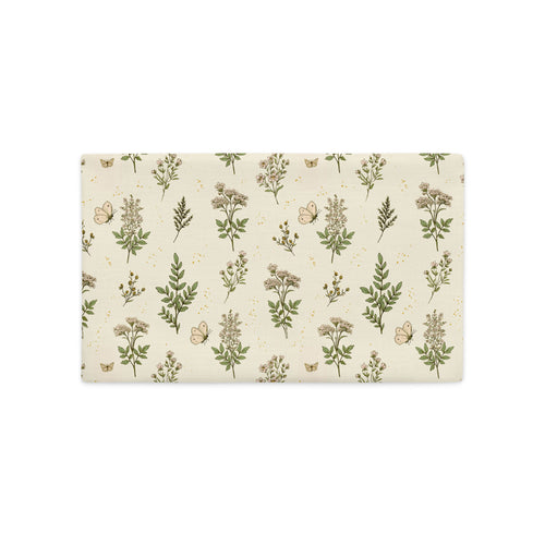 A rectangular placemat with a botanical pattern featuring green leaves, beige flowers, and small butterflies on a cream background, shown on a solid white background.
