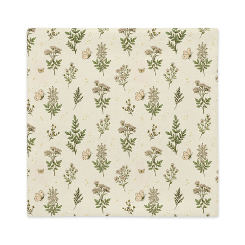 A square fabric napkin or placemat featuring a vintage botanical pattern with green leaves, beige flowers, and butterflies on a cream background, shown flat against a white backdrop.