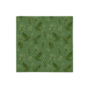A square fabric or paper napkin featuring a repeating botanical pattern of green ferns and small white flowers on a muted sage green background, shown flat against a white backdrop.
