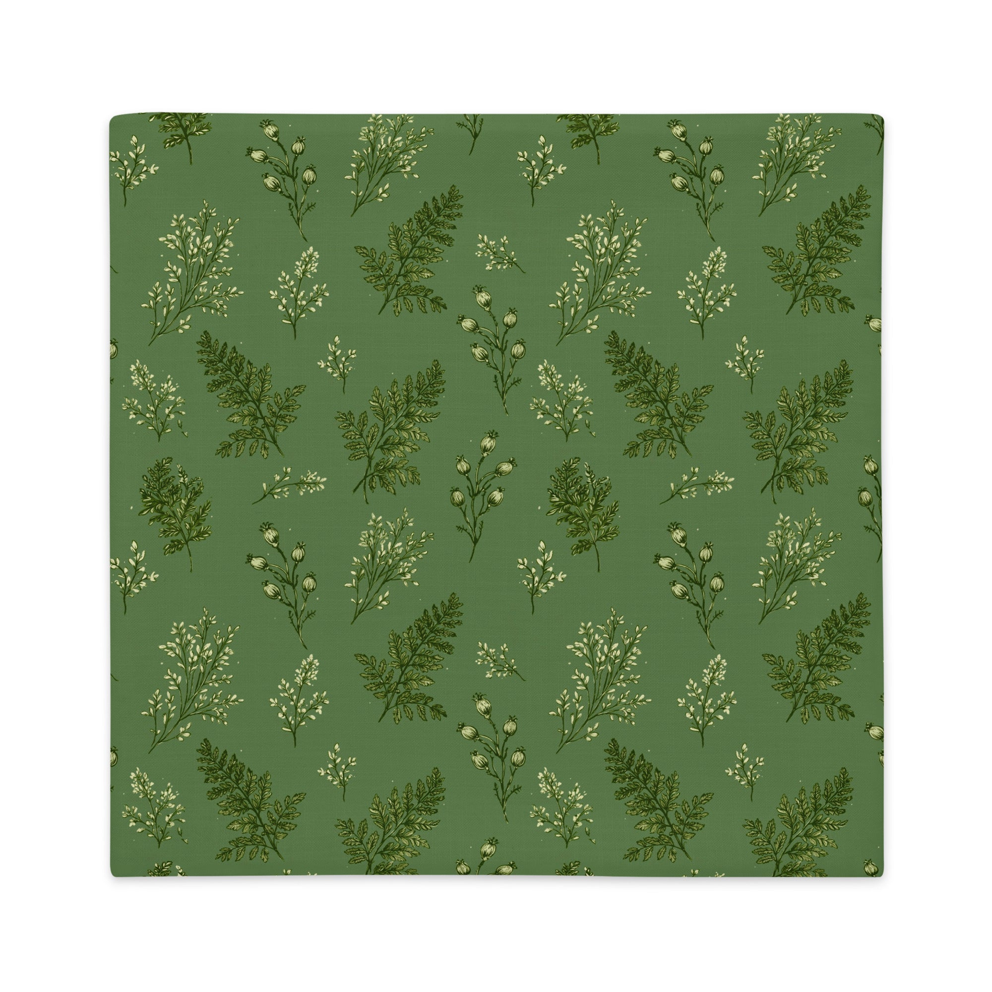 A square fabric item, likely a placemat or napkin, featuring a repeating pattern of green ferns and small white flowers on a muted sage green background.