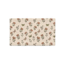 A rectangular fabric placemat or desk mat featuring a vintage-style botanical pattern with poppy flowers, wildflowers, and butterflies on a warm beige background.