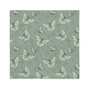 A square pillow cover with a repeating pattern of pale green butterflies and small gold floral details on a muted sage green background, shown against a plain white backdrop.